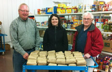 Bruce Street, President of the Crowsnest Pass Food Bank, accepts a donation of beef to the Crowsnest Pass Food Bank from  Dr. Kristy Penner (centre) and Dr. Allan Garbutt (right)